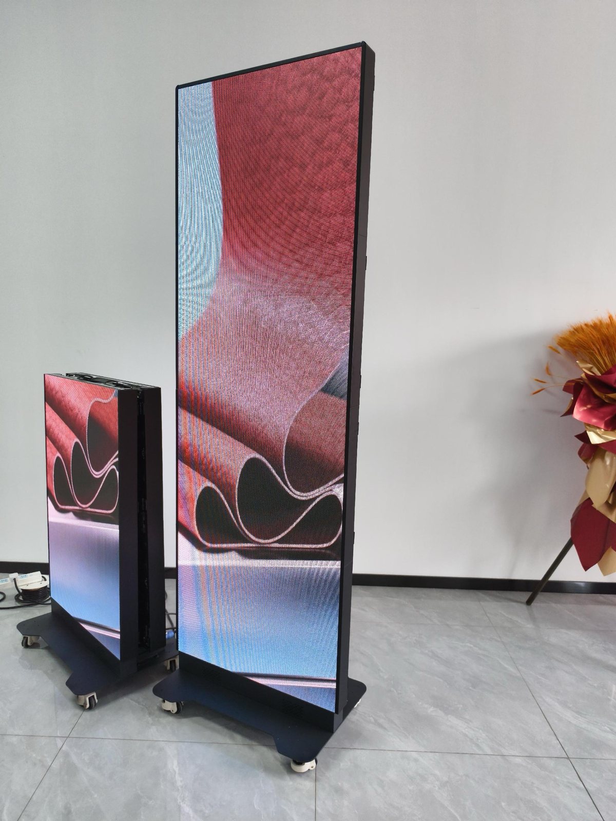 Indoor LED posters on casters, front view, showing colorful content in our showroom